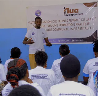 Session de formation communautaire animée devant un groupe de jeunes femmes.